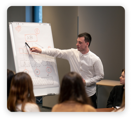 man explaining to a crowd with a graph on whiteboard