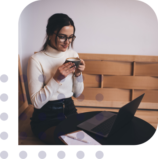 Girl with a cup of coffee in front of laptop